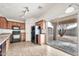 Kitchen with wood cabinets, black appliances, tile floors, and sliding glass door leading to the backyard at 11765 W Maui Ln, El Mirage, AZ 85335