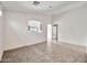 Spacious living room with neutral walls, tile floors and open archway into the kitchen at 11765 W Maui Ln, El Mirage, AZ 85335