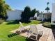 Lawn chairs sitting on a red tile patio overlooking a lush green backyard and providing a relaxing outdoor space at 120 E Calavar Rd, Phoenix, AZ 85022