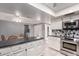 Well-lit kitchen featuring black countertops, stainless steel appliances and tile backsplash at 120 E Calavar Rd, Phoenix, AZ 85022