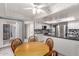 Eat-in kitchen with ceiling fan, wooden dining table, and white cabinets at 120 E Calavar Rd, Phoenix, AZ 85022