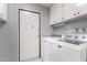 Laundry room with a washer, a dryer, and overhead cabinets for storage at 120 E Calavar Rd, Phoenix, AZ 85022