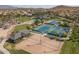 Aerial view of community amenities, including tennis and volleyball courts, nestled in a lush, landscaped setting at 12231 S 185Th Ave, Goodyear, AZ 85338