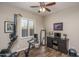 Bright exercise room features wood-look floors, ceiling fan and exercise equipment with a view to the outside at 12231 S 185Th Ave, Goodyear, AZ 85338