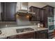 Close-up of kitchen featuring granite countertops, stainless steel appliances, and dark wood cabinetry at 12231 S 185Th Ave, Goodyear, AZ 85338