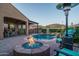 Inviting backyard with a pool, fire pit, outdoor seating, and a covered dining area, ideal for entertaining at 12231 S 185Th Ave, Goodyear, AZ 85338