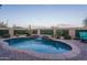 Beautiful pool with waterfall feature, surrounded by lush landscaping and stone pavers at 12231 S 185Th Ave, Goodyear, AZ 85338