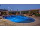 Stunning pool with underwater lighting and a waterfall feature, set against a backdrop of desert landscaping at 12231 S 185Th Ave, Goodyear, AZ 85338