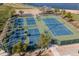 Overhead view of blue tennis courts with green surroundings and trees that add natural beauty and shade at 12231 S 185Th Ave, Goodyear, AZ 85338