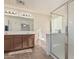 Bathroom featuring a double vanity, tile flooring, and a glass-enclosed shower at 12509 W Whyman St, Avondale, AZ 85323