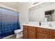 Bathroom featuring shower-tub combo with curtain, toilet, and wooden vanity with a white countertop sink at 12509 W Whyman St, Avondale, AZ 85323