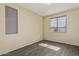 Empty bedroom featuring wood-look tile flooring, neutral walls, and two windows at 12509 W Whyman St, Avondale, AZ 85323