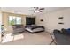 Bedroom with neutral walls, carpet, ceiling fan, furniture, and a window overlooking a green landscape at 12509 W Whyman St, Avondale, AZ 85323