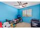 A bright bedroom in blue tones that includes a ceiling fan, a window, and a toddler bed at 12509 W Whyman St, Avondale, AZ 85323