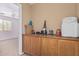 Hallway featuring oak cabinets, an adjacent room with a ceiling fan, and a window with natural light at 12509 W Whyman St, Avondale, AZ 85323