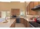 Well-lit kitchen featuring wood cabinetry, tile flooring, stainless steel appliances, and a large island at 12509 W Whyman St, Avondale, AZ 85323