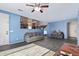 Open-concept living room with gray couches, tile flooring, and natural light at 12509 W Whyman St, Avondale, AZ 85323