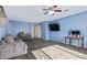 Spacious living room with a ceiling fan, dark flooring, and comfortable gray couches at 12509 W Whyman St, Avondale, AZ 85323