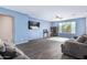 Bright living room with a ceiling fan, dark flooring, and comfortable gray couches at 12509 W Whyman St, Avondale, AZ 85323