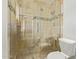 Bathroom featuring a glass shower with decorative stone tiling, toilet, and neutral color palette at 1409 E Verlea Dr, Tempe, AZ 85282