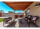 Relaxing covered patio featuring an outdoor kitchen, grill, seating, and stylish wicker chairs with decorative pillows at 1409 E Verlea Dr, Tempe, AZ 85282