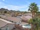 Aerial view with houses, a pool, palm trees, and mountains in the distance at 16611 N 19Th St, Phoenix, AZ 85022