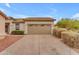 Exterior front view of the home featuring a two-car garage, desert landscaping, and mature bushes at 16611 N 19Th St, Phoenix, AZ 85022