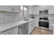 Modern kitchen with white cabinets, stainless steel appliances, subway tile, and a view from the window at 16611 N 19Th St, Phoenix, AZ 85022