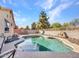 Backyard with a pebble lined pool and rock landscaping, and a view of the surrounding homes at 18556 W Vogel Ave, Goodyear, AZ 85338