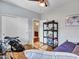 Bedroom with hardwood floors, bed, shelves, closet with sliding doors, and a view into the bathroom at 18556 W Vogel Ave, Goodyear, AZ 85338