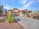 Single-story home with desert landscaping, long driveway, and attached garage at 18556 W Vogel Ave, Goodyear, AZ 85338