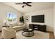 Cozy living room with a comfortable sofa, ceiling fan, television, and a neutral color palette at 18845 N 43Rd St, Phoenix, AZ 85050