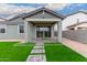 Inviting covered back patio with sliding glass doors and lush artificial grass, perfect for outdoor living at 21743 N Daniel Dr, Maricopa, AZ 85138