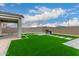 A backyard featuring artificial grass, grilling area, stone paver steps, and a covered patio at 21743 N Daniel Dr, Maricopa, AZ 85138