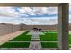 An expansive backyard featuring artificial grass, grilling area, and a charming stone paver pathway at 21743 N Daniel Dr, Maricopa, AZ 85138