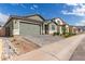 Charming home with a green garage and desert landscaping, creating a welcoming and low-maintenance curb appeal at 21743 N Daniel Dr, Maricopa, AZ 85138