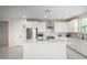 Bright kitchen featuring an island, white cabinetry, stainless steel appliances, and marble flooring at 21743 N Daniel Dr, Maricopa, AZ 85138