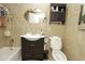 Well-lit bathroom features tiled walls, storage cabinet, toilet, tub, and oval mirror at 2201 W Wethersfield Rd, Phoenix, AZ 85029