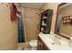 This bathroom features tiled walls, open shelf, toilet, shower, and framed mirror at 2201 W Wethersfield Rd, Phoenix, AZ 85029