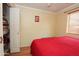 Bright bedroom with red bedding, closet and bright window with laminate flooring at 2201 W Wethersfield Rd, Phoenix, AZ 85029