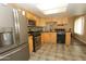 Well-lit kitchen equipped with stainless steel appliances, wooden cabinets, and gray tile floors at 2201 W Wethersfield Rd, Phoenix, AZ 85029