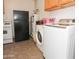 Functional laundry area equipped with a washer, dryer, stove, and refrigerator at 2201 W Wethersfield Rd, Phoenix, AZ 85029