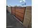 Side yard access provided by a modern horizontal plank gate set within brick walls at 2255 W Bloomfield Rd, Phoenix, AZ 85029