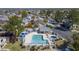 Aerial view of a community pool with blue umbrellas and a hot tub surrounded by lush landscaping at 2455 E Broadway Rd # 102, Mesa, AZ 85204