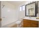 Bathroom featuring a bathtub, shower, toilet, single sink vanity, and framed mirror at 2455 E Broadway Rd # 102, Mesa, AZ 85204