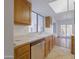 Functional kitchen with wood cabinets, stainless steel dishwasher, and a bright window above the sink at 2455 E Broadway Rd # 102, Mesa, AZ 85204