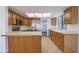 Well-lit kitchen featuring wooden cabinets, stainless steel appliances, and a view into an adjacent living space at 2455 E Broadway Rd # 102, Mesa, AZ 85204