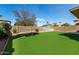 Fenced backyard featuring artificial grass, a storage shed, and mature trees at 2546 E Camellia Dr, Gilbert, AZ 85296