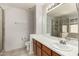 Bathroom with double vanity, large mirror, and tiled floors, adjacent to a tiled glass shower at 2546 E Camellia Dr, Gilbert, AZ 85296