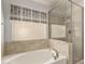 Bathroom featuring a soaking tub and walk-in shower stall with beautiful neutral tile at 2546 E Camellia Dr, Gilbert, AZ 85296